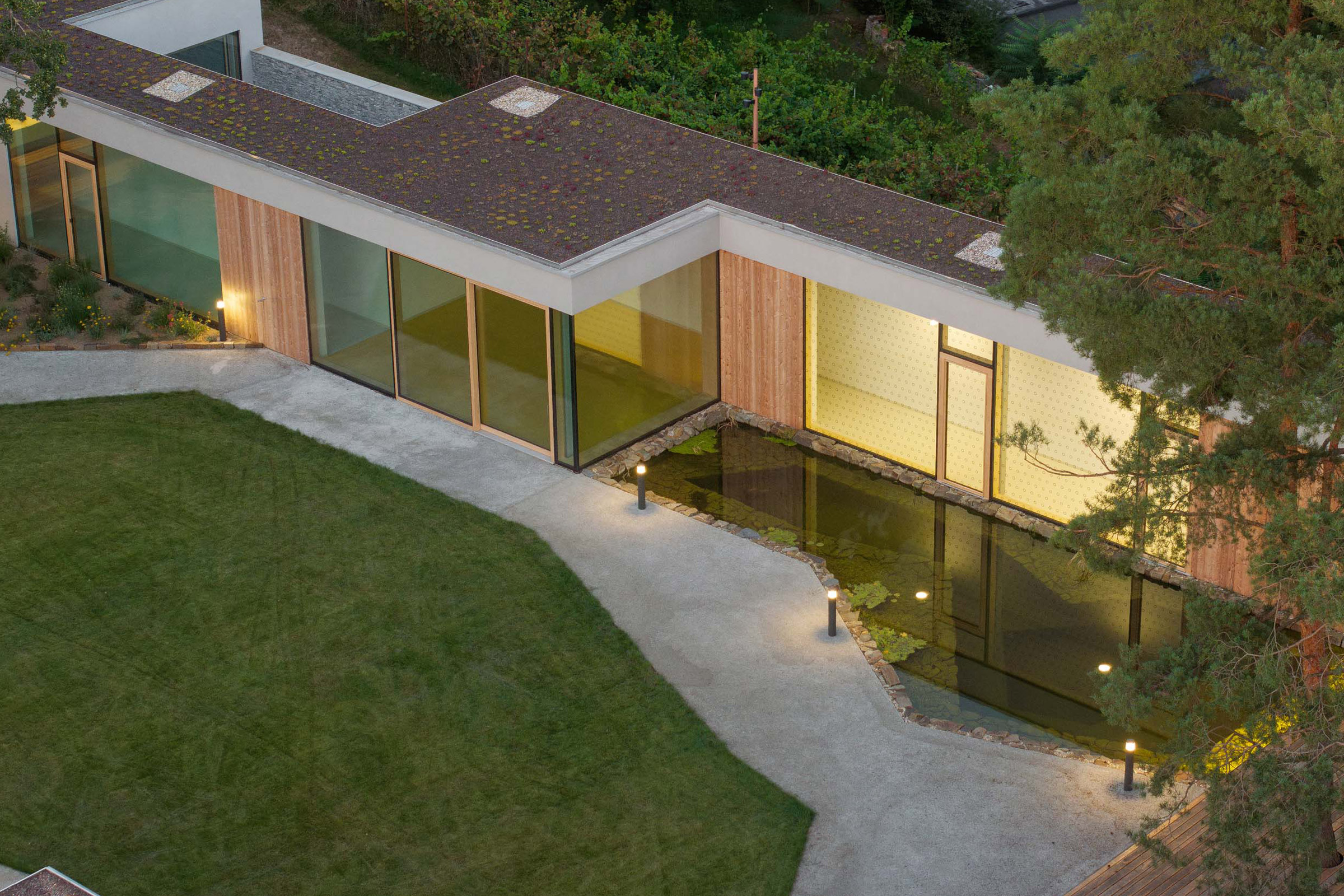 Betonově šedé broušené omítky StoSignature doplňují dřevěné obklady modřínových biodesek 