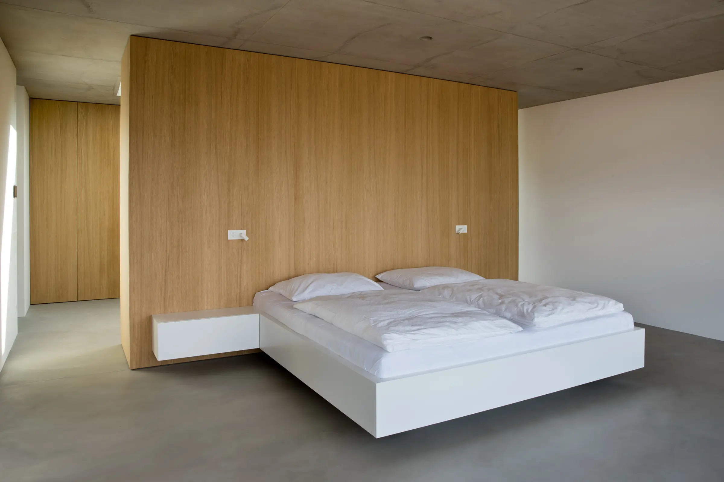 Moderní ložnice s minimalistickým interiérem.