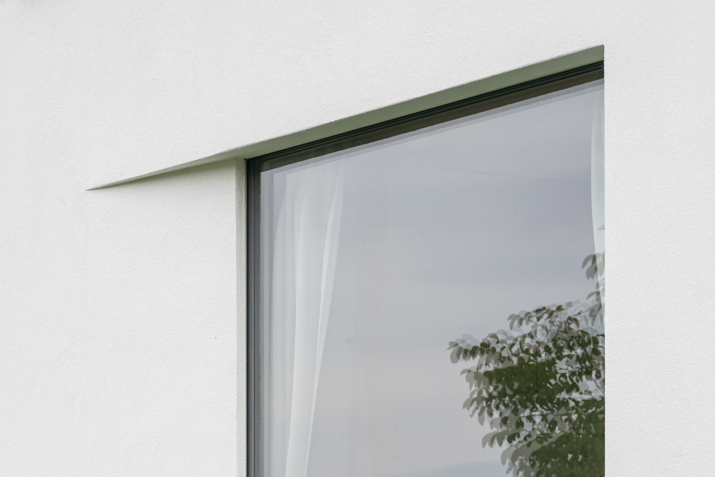 Detail bílé fasády s jemnými horizontálními profily StoDeco