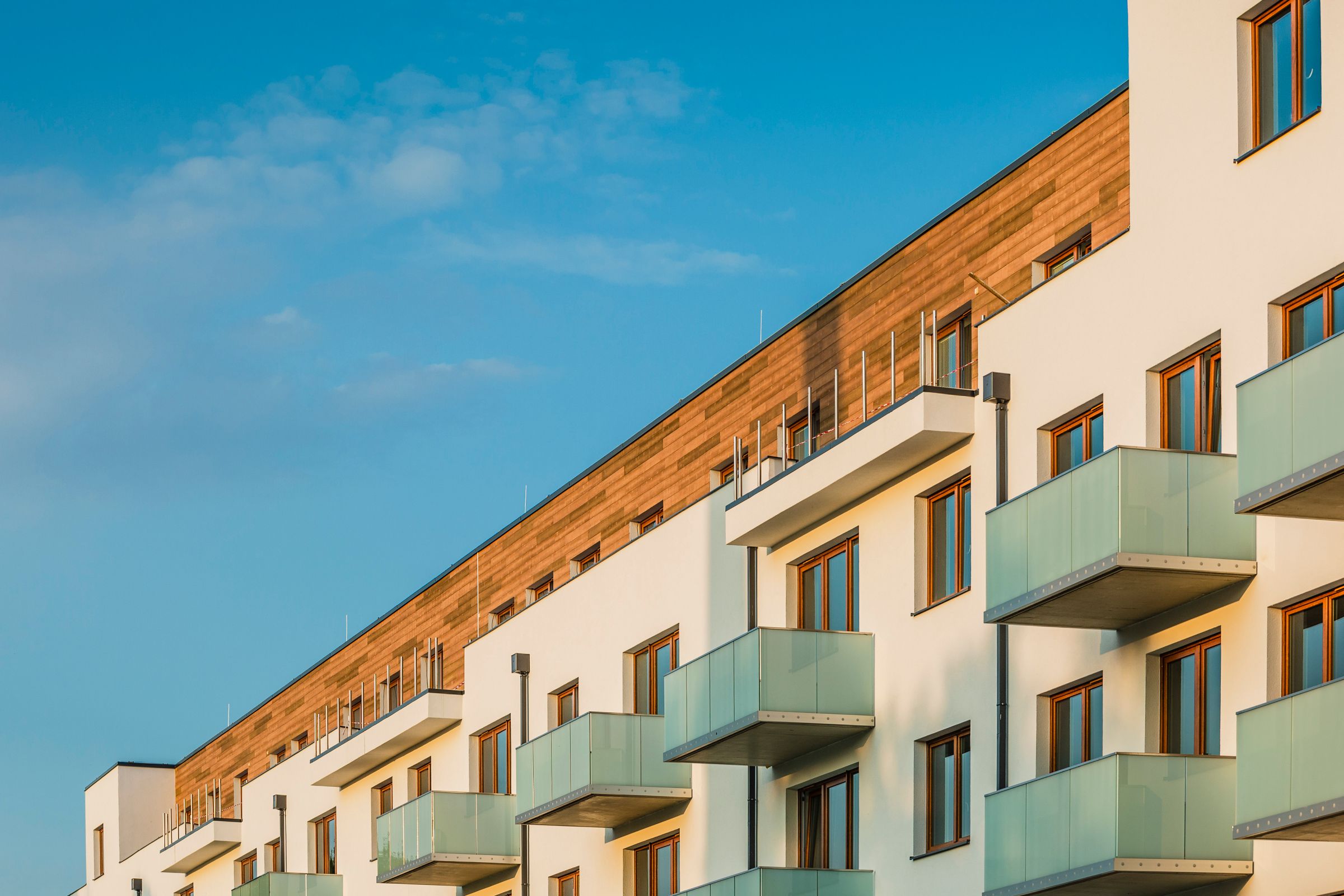 Fasádu rezidenčního projektu Byty Šibeník v Olomouci zdobí kombinace obkladů se vzhledem dřeva a omí